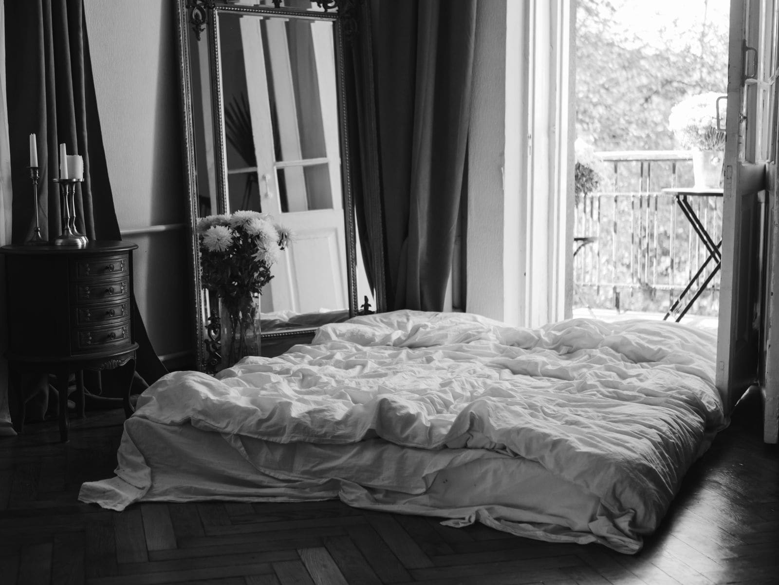 Simple made-up bed with plain linen in a bare shared room