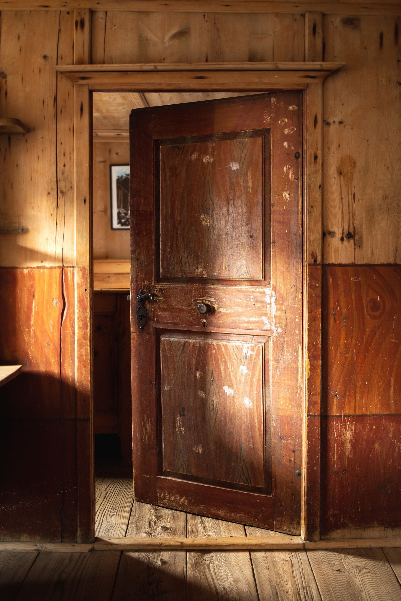 Interior of a wooden cabin with the door standing open