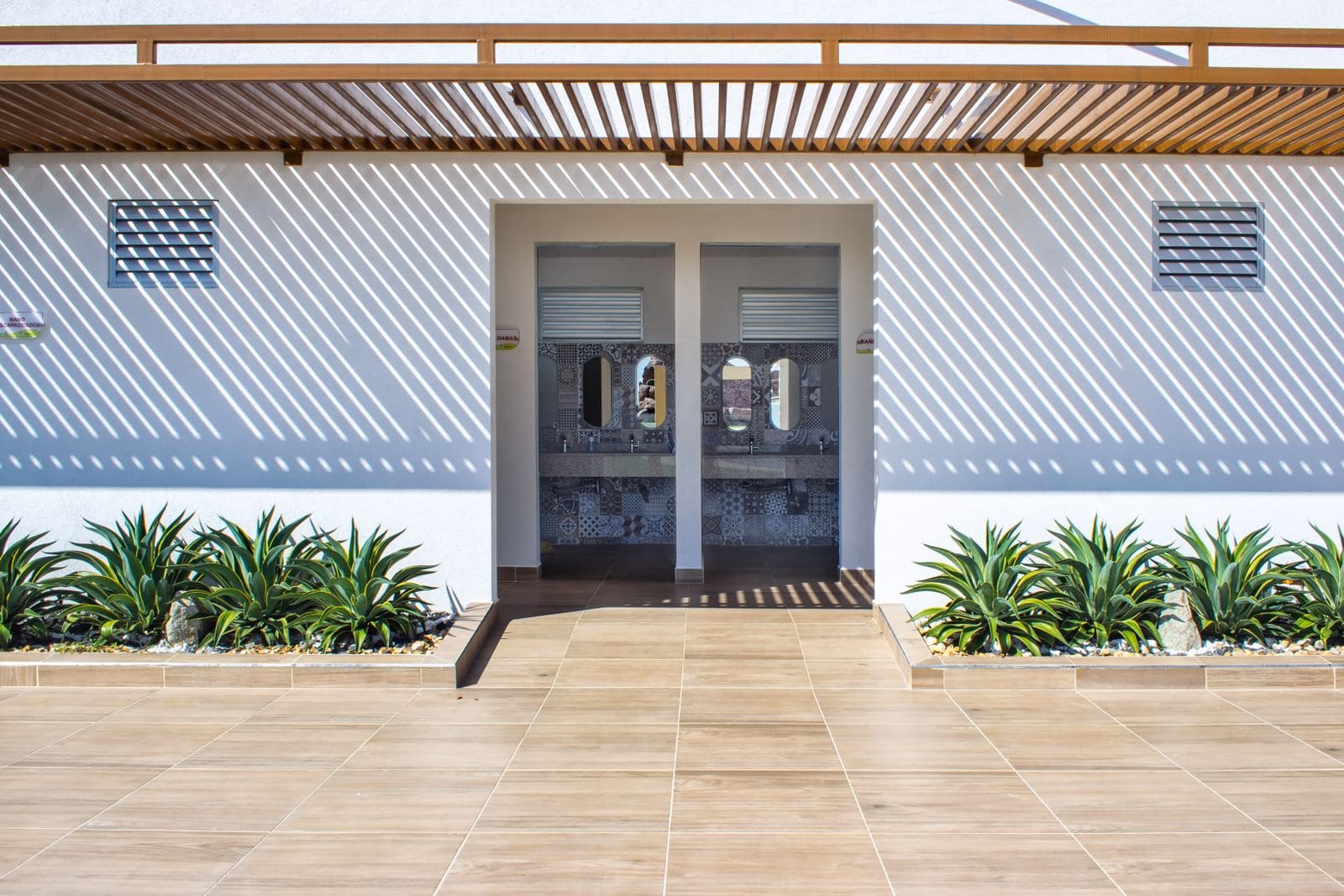 White resort building facade with wooden slat shading