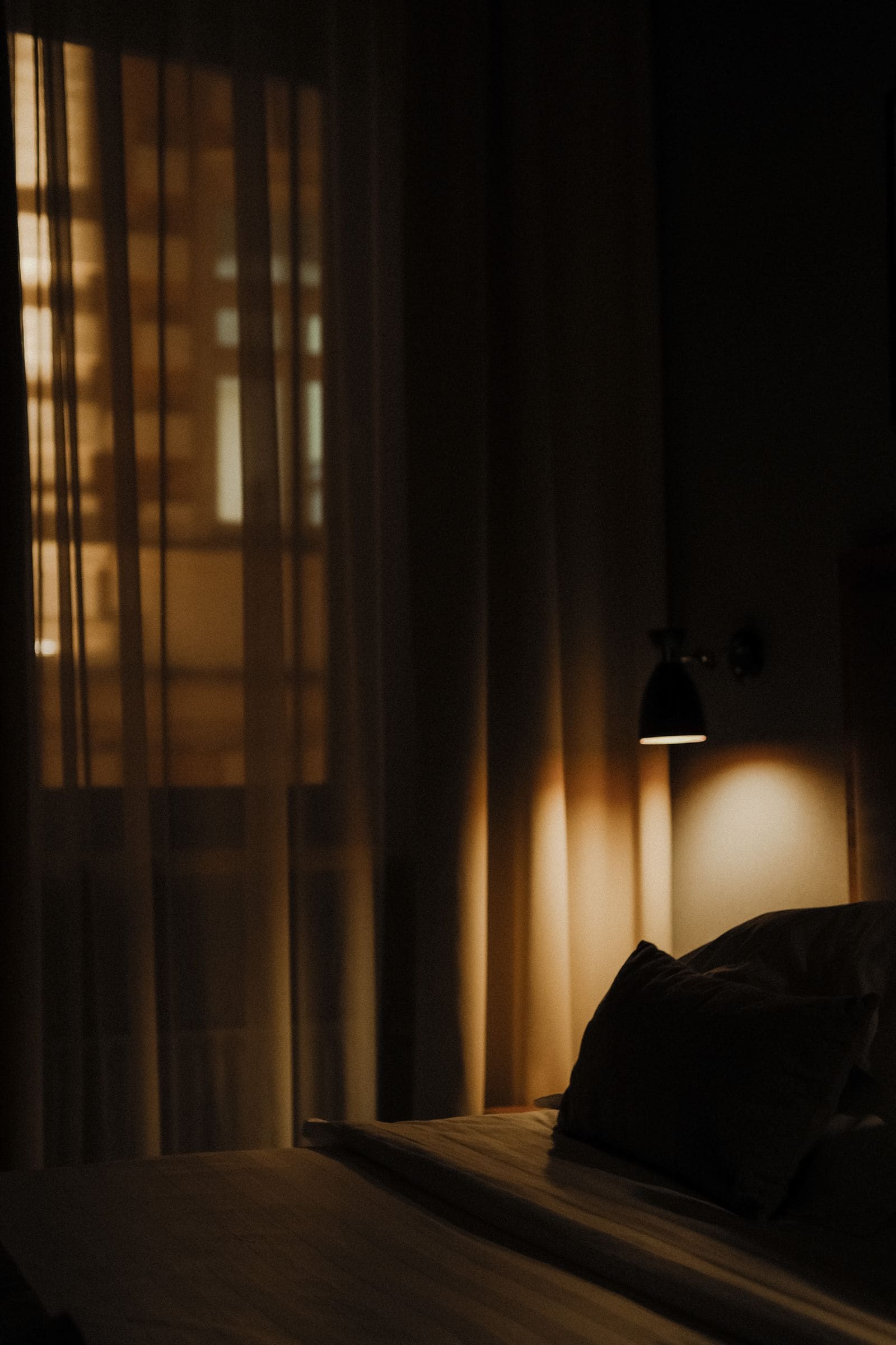 Dimly lit hotel room with the curtains drawn across the window