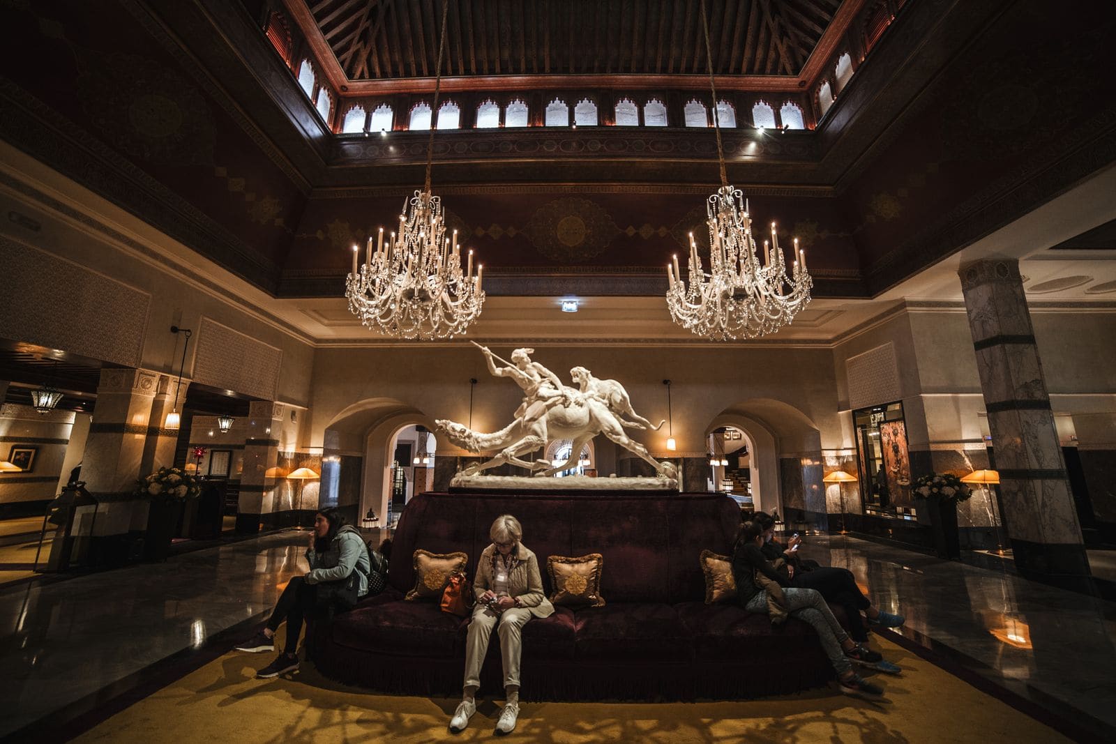 Spacious hotel lobby with chandeliers and seating