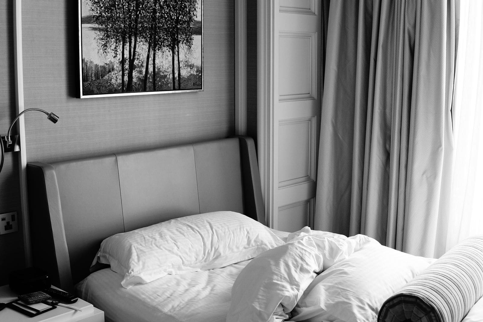 Black and white photograph of a bed in a bedroom