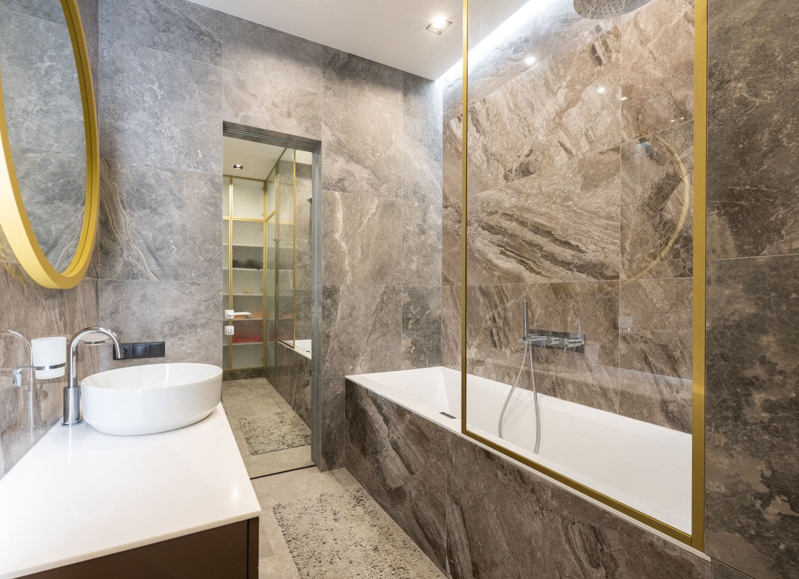 Bathroom with a sink and faucet on a counter beside the bath