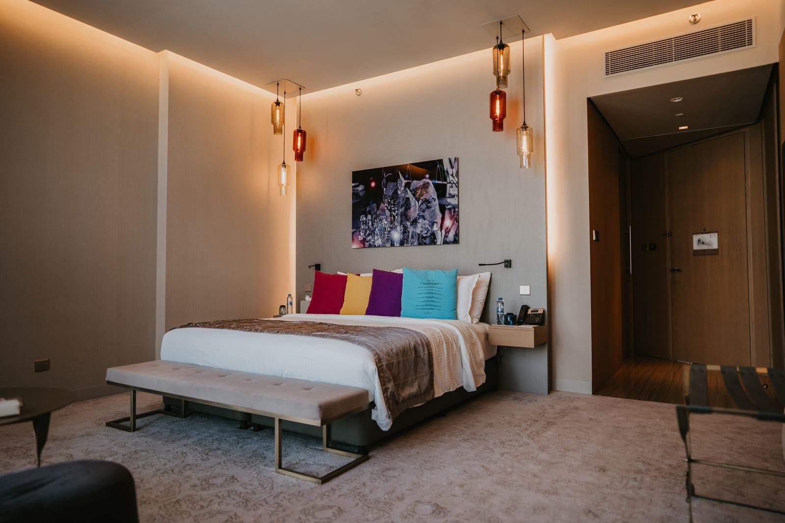 Bedroom with a bed, a lamp and a framed painting