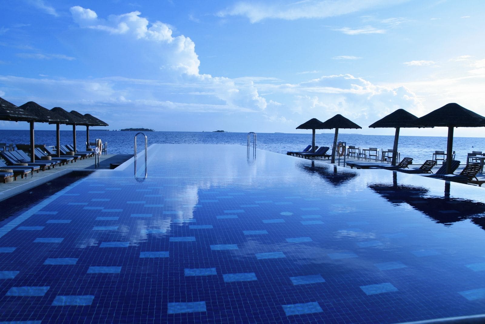 Lounge chairs arranged around an infinity pool
