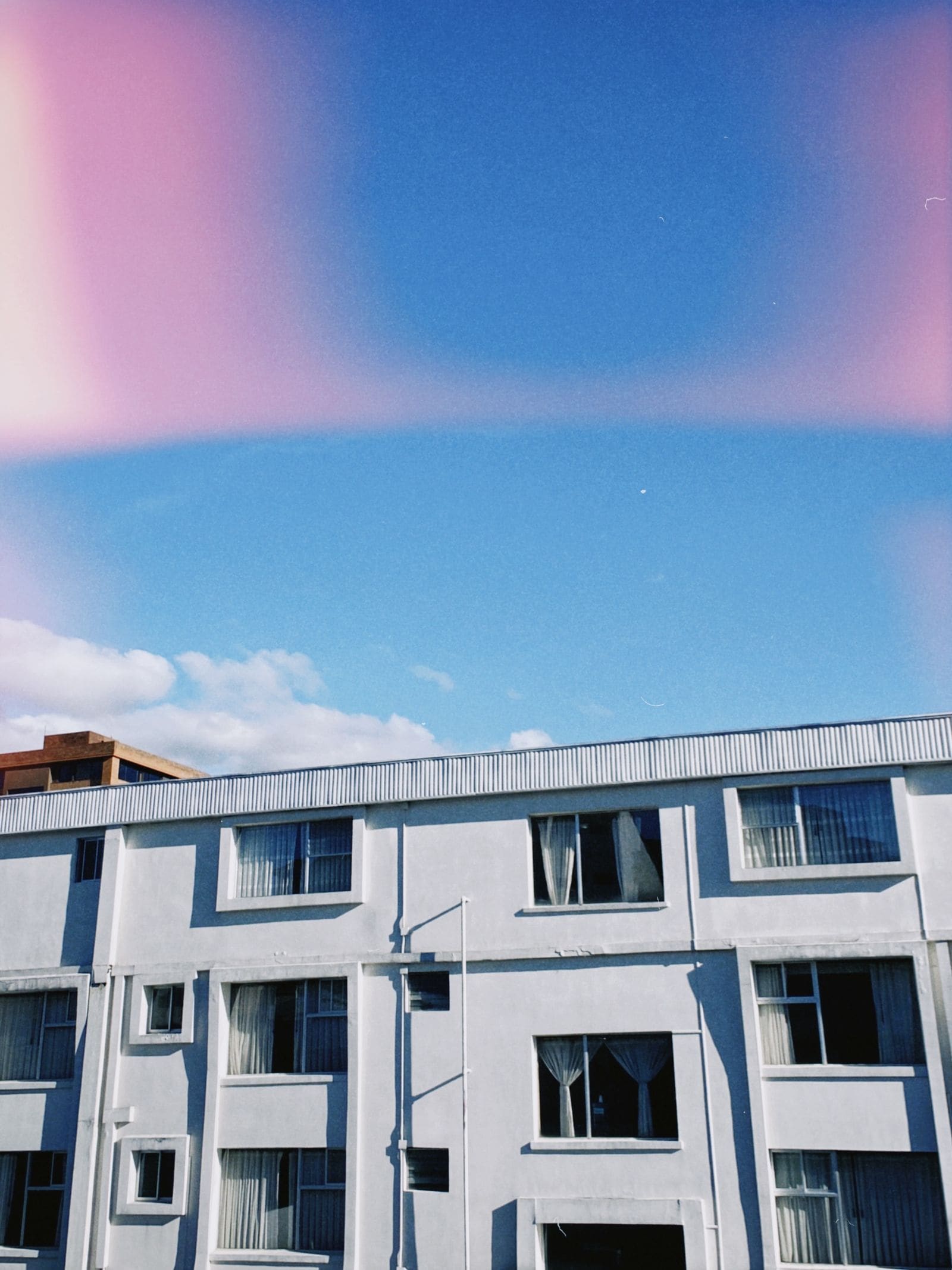 Modern white apartment building against a blue sky