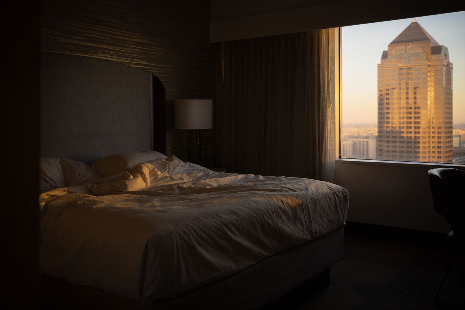 Skyscraper seen through the window of a hotel bedroom