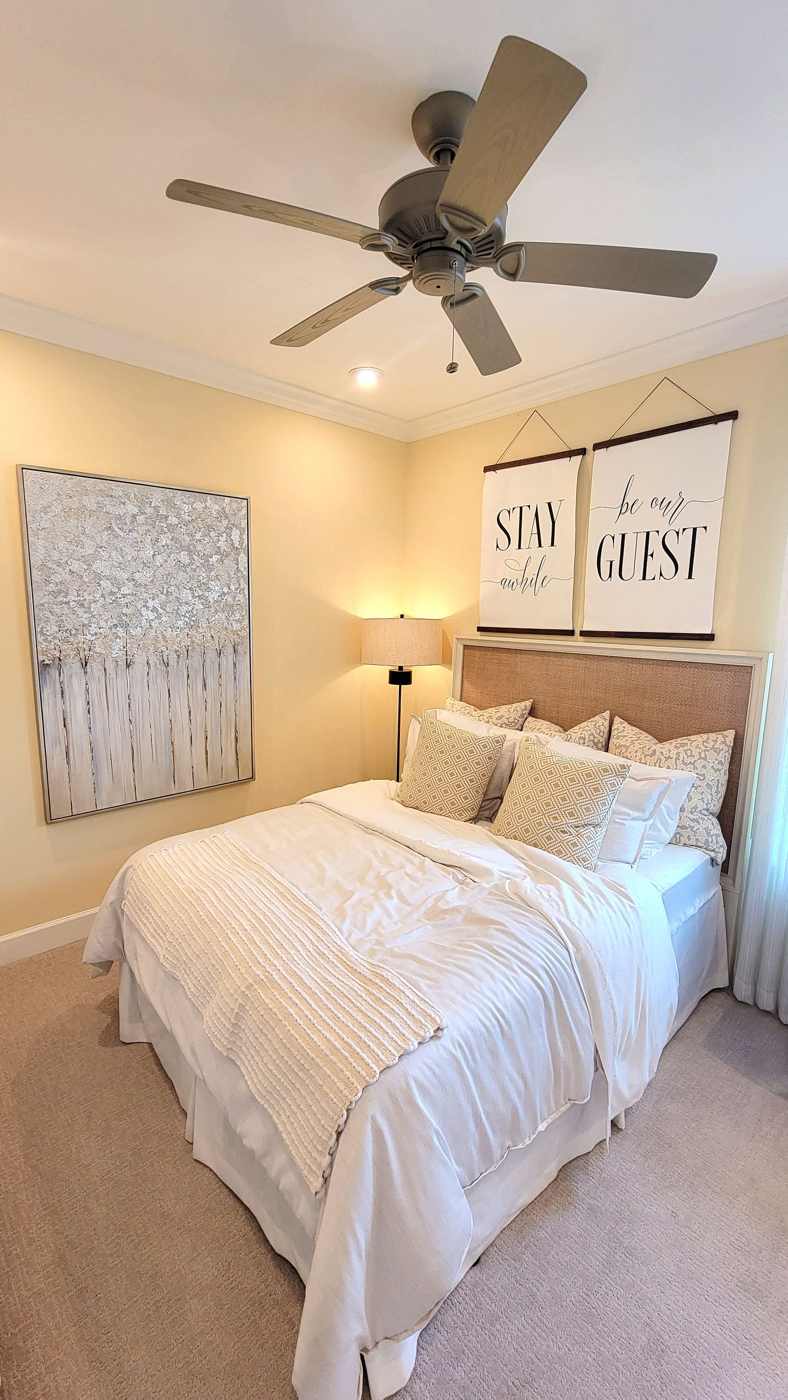 Bed in a bright hotel room with neutral tones