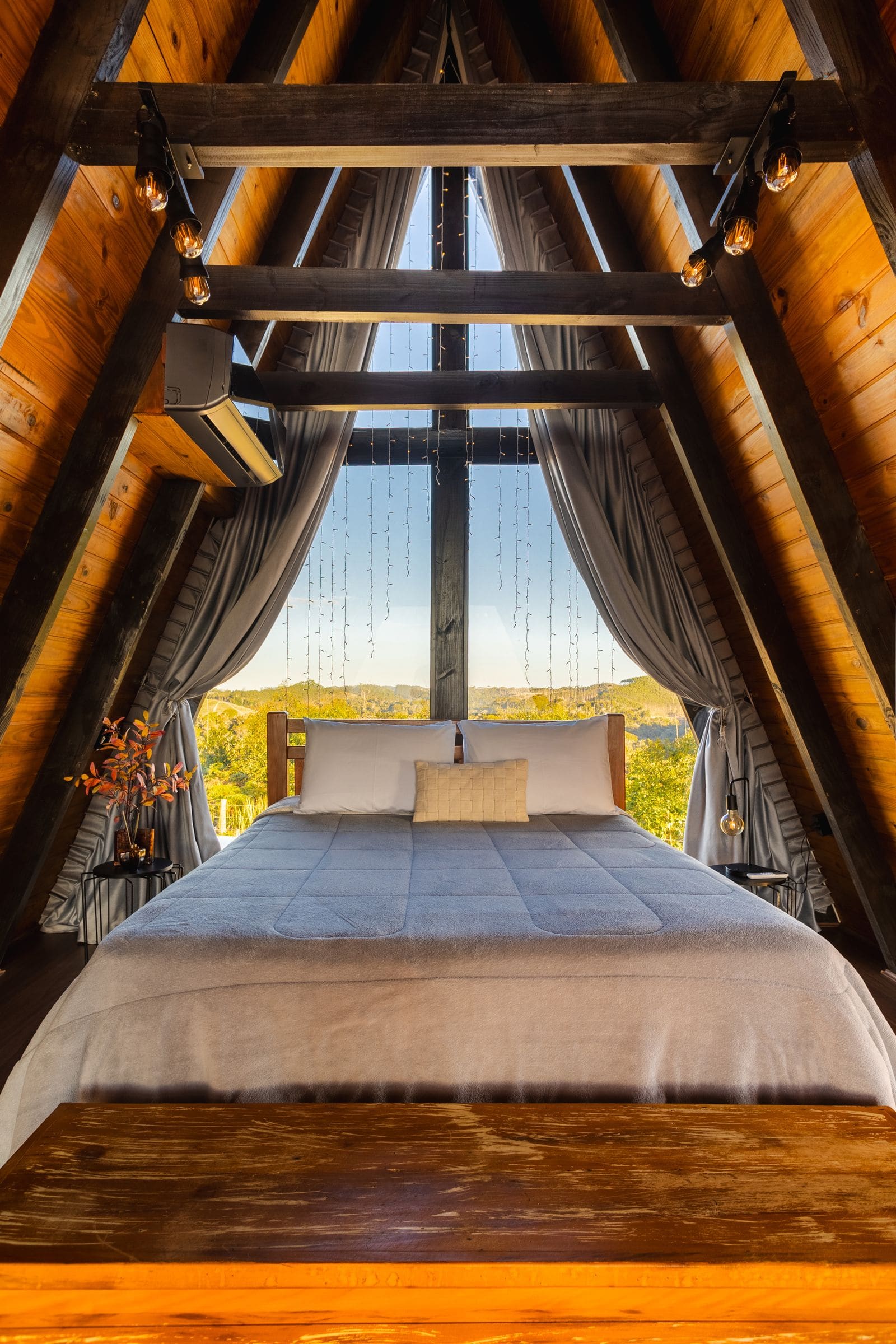 Bed in a bedroom with a bright window behind it