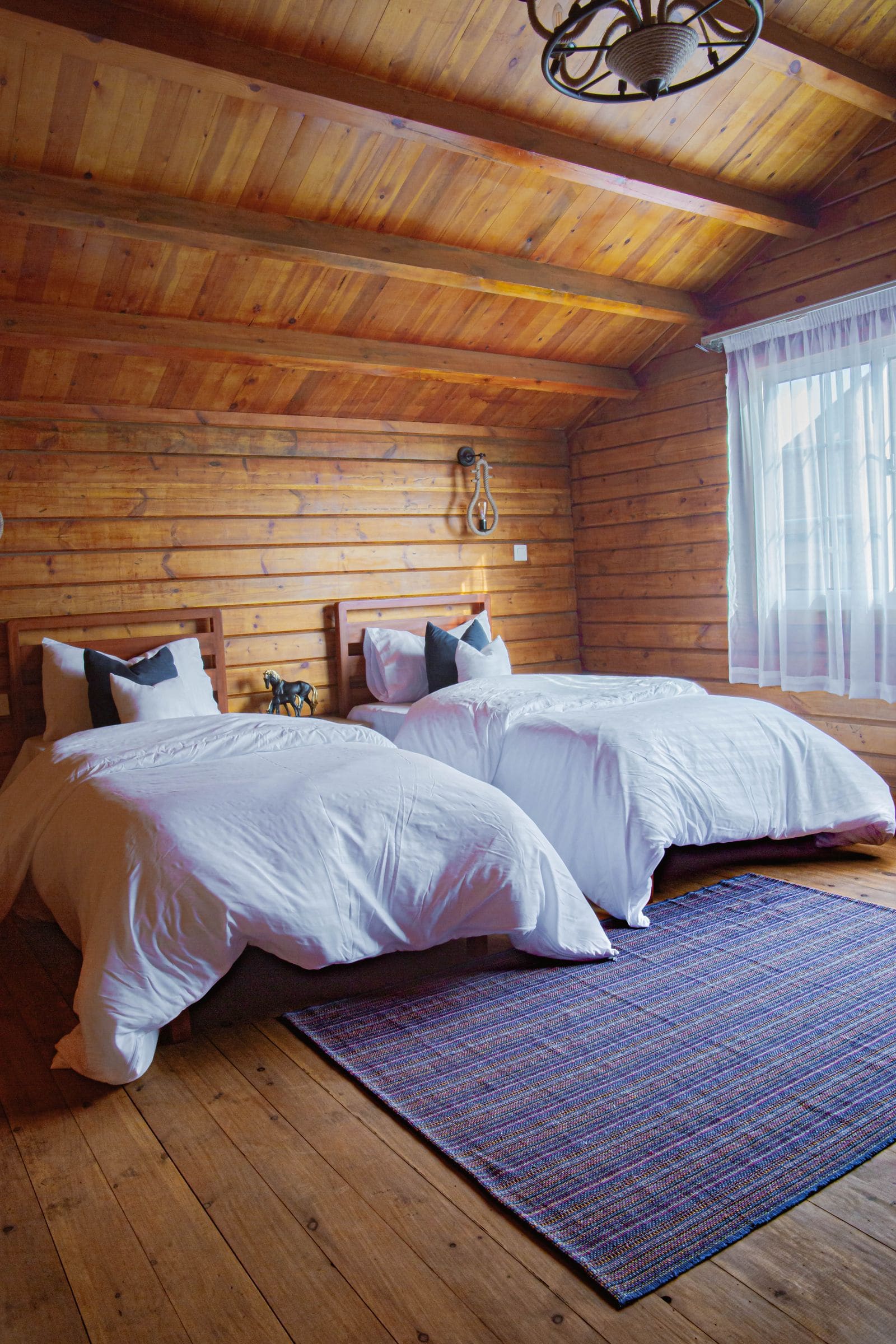 Wooden hotel room with beds in crisp white sheets