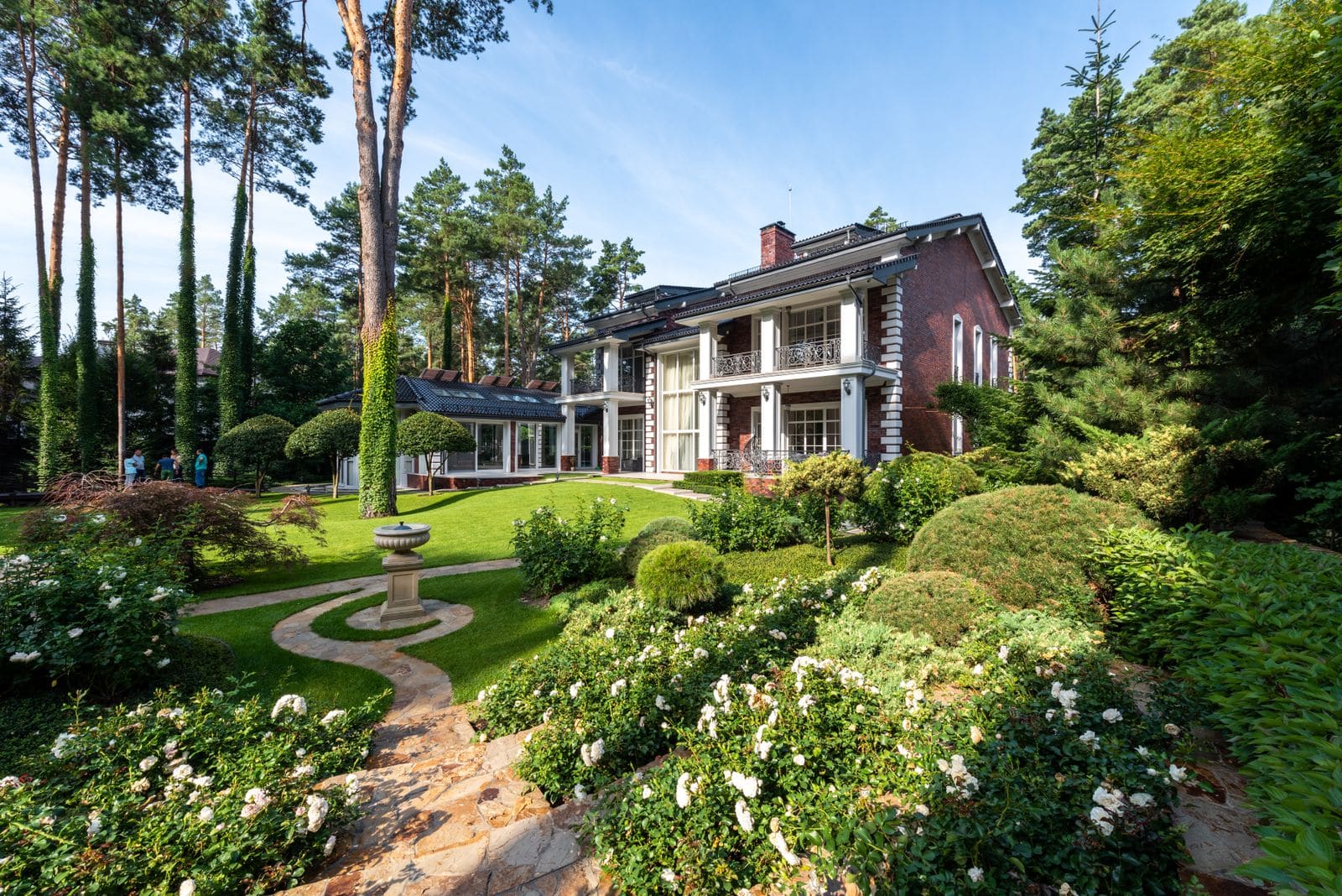 Cottage exterior with a planted garden and paved pathways leading to the door